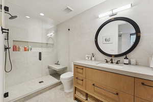 Bathroom with a stall shower, vanity, tile walls, recessed lighting, and light tile patterned flooring