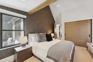 Carpeted bedroom featuring a closet and wallpapered walls