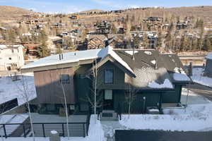 Snowy aerial view featuring a mountain view and a residential view