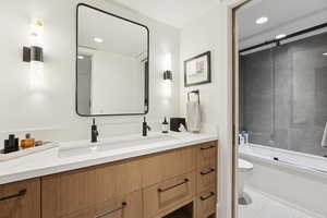 Bathroom featuring vanity, shower / bath combination with glass door, and recessed lighting
