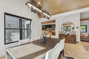 Dining space with wooden ceiling, light wood-style flooring, and lofted ceiling