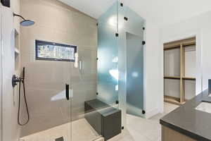 Bathroom featuring vanity, a shower stall, and light tile patterned floors