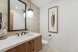 Half bathroom with vanity, tile walls, light tile patterned flooring, and recessed lighting