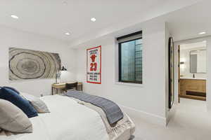 Carpeted bedroom with recessed lighting and ensuite bathroom