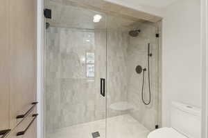 Bathroom featuring toilet and a stall shower