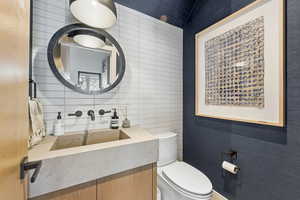 Bathroom with vanity, tile walls, and decorative backsplash