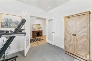 Workout area with light colored carpet and baseboards