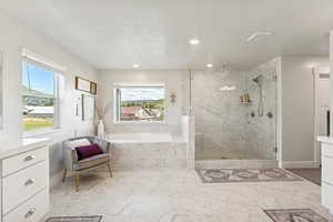 Bathroom featuring a marble finish shower, a garden tub, a textured ceiling, vanity, and recessed lighting
