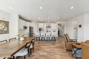 Dining area with light wood-style flooring, recessed lighting, and a textured ceiling