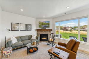 Living area with light wood-type flooring, a fireplace, a textured ceiling, and recessed lighting