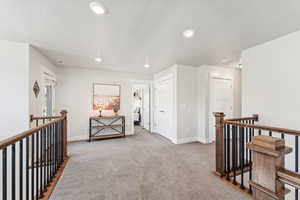 Corridor featuring an upstairs landing, light carpet, a textured ceiling, and recessed lighting