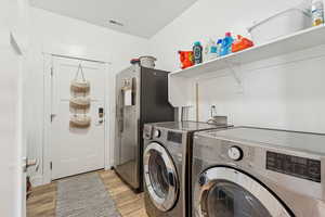 Laundry room featuring light wood finished floors and independent washer and dryer