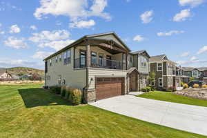 View of front of house with stone siding, driveway, a front yard, a garage, and a mountain view