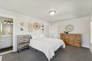 Bedroom with dark colored carpet and ensuite bathroom
