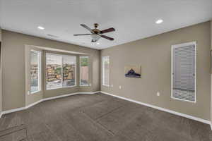 Carpeted spare room featuring a ceiling fan and recessed lighting