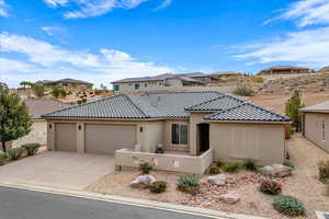 Mediterranean / spanish home featuring stucco siding, concrete driveway, an attached garage, and a tile roof