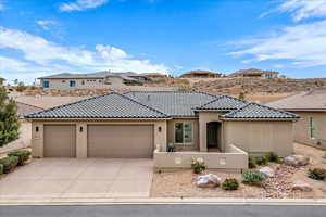 Mediterranean / spanish house featuring stucco siding, driveway, an attached garage, and a tiled roof