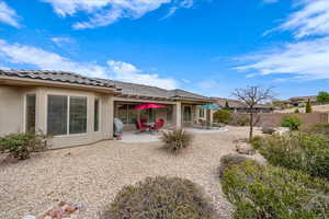 Back of house with a patio area, stucco siding, and a tile roof