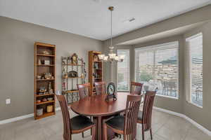 Dining area featuring light tile patterned floors and a chandelier