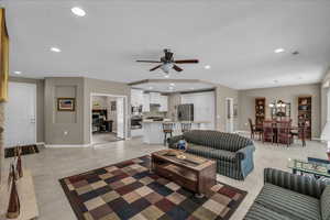 Living room featuring light tile patterned flooring, recessed lighting, ceiling fan, and a textured ceiling