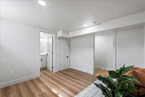 Below grade area with light wood-style flooring and recessed lighting