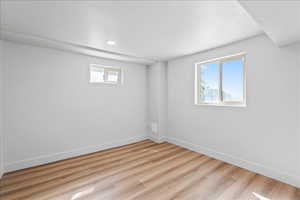 Below grade area featuring light wood-type flooring and recessed lighting