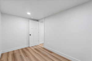 Empty room with light wood finished floors and recessed lighting
