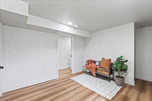 Sitting room with wood finished floors and recessed lighting