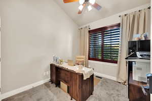 Office area featuring vaulted ceiling, ceiling fan, and light colored carpet