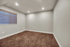 Carpeted spare room with recessed lighting and baseboards