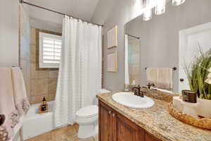 Bathroom with shower / bath combination with curtain, vanity, and light tile patterned flooring