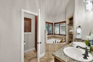 Bathroom featuring a bath, double vanity, light tile patterned flooring, and a stall shower