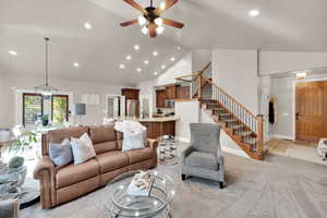 Living area featuring recessed lighting, light colored carpet, stairs, high vaulted ceiling, and ceiling fan