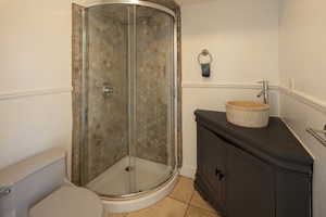 Bathroom featuring a shower stall and light tile patterned floors