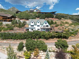 Aerial view of property and surrounding area with a mountainous background