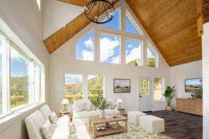 Living room with high vaulted ceiling, dark wood-style floors, healthy amount of natural light, and wooden ceiling (Virtually staged)