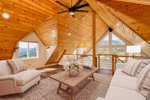 Living room featuring light wood-style floors, wooden ceiling, and a ceiling fan (Virtually staged)