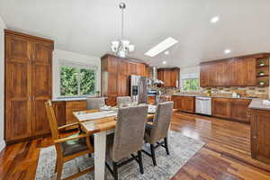 Dining room featuring a skylight, hardwood floors, recessed lighting, and a chandelier