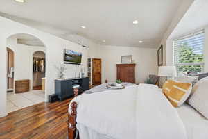 Primary Bedroom featuring a walk in closet and arched walkways