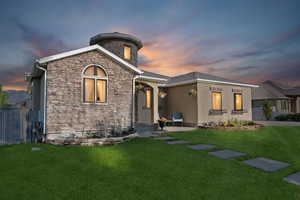 Evening view of front of home with stone and stucco siding