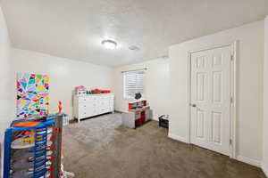 Bedroom #4 with carpet and a textured ceiling