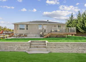 Rear view of home featuring tiered, flat yard.
