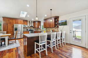 Large kitchen featuring a skylight, decorative backsplash, and pendant lights