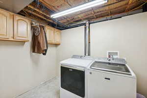 Laundry area featuring washer and dryer and cabinet space
