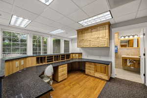 Unfurnished reception area with dark colored carpet and a paneled ceiling