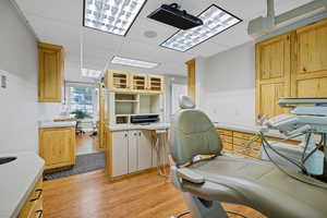 Procedure room a drop ceiling and light wood finished floors