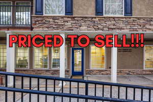 Doorway to property featuring stone siding and stucco siding