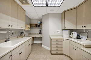 Lab room with cabinets, drop ceiling, a sink and tile floors