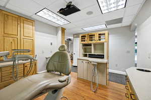 Procedure room a drop ceiling and light wood finished floors