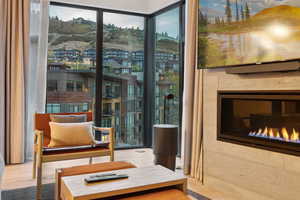 Sitting room featuring a desk, wood finished floors, and a glass covered fireplace